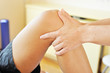 Osteopath untersucht ein Knie