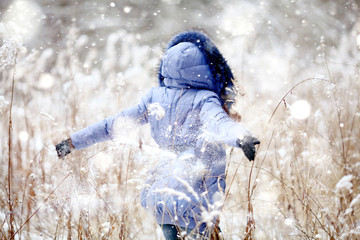 Wall Mural - Girl having fun and jumping in the snow