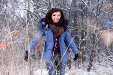 Wall Mural - Girl having fun and jumping in the snow