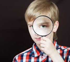 Wall Mural - Portrait of a boy looking through the magnifying glass