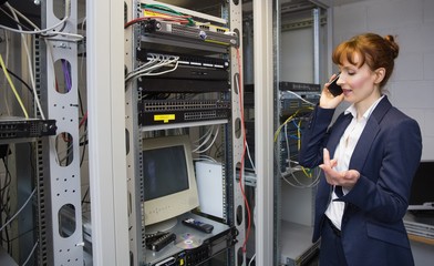 Aufkleber - Pretty computer technician talking on phone beside open server