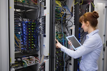 Poster - Technician using tablet pc while analysing server