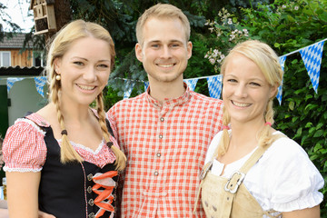 Wall Mural - Freunde in Dirndl und Tracht im Biergarten