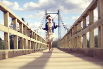 Wall Mural - happy girl dress runs over the bridge