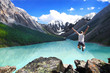 Beautiful mountain landscape with the lake and the jumping man