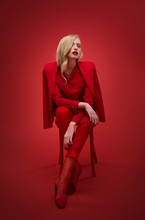 Stylish Woman In Red Suit In Studio
