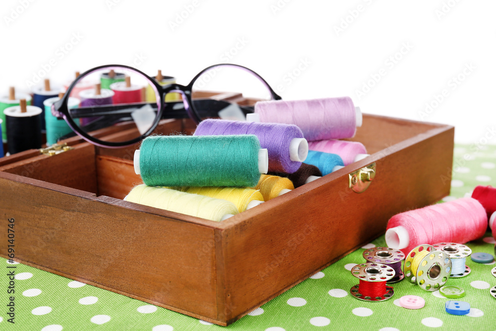 Colorful threads for needlework in wooden box close up