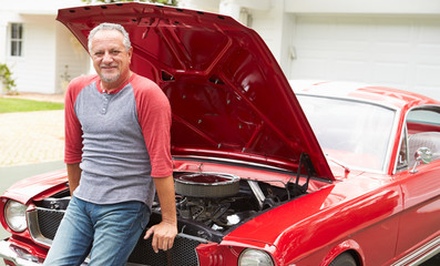 Retired Senior Man Working On Restored Classic Car