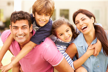 Portrait Of Happy Family In Garden At Home