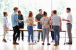© Monkey Business - Teacher With College Students Standing By Desks In Classroom