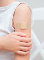 child arm with an adhesive bandage.