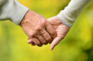 Elderly couple holding hands