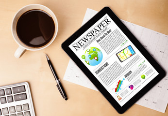 Wall Mural - tablet pc shows news on screen with a cup of coffee on a desk