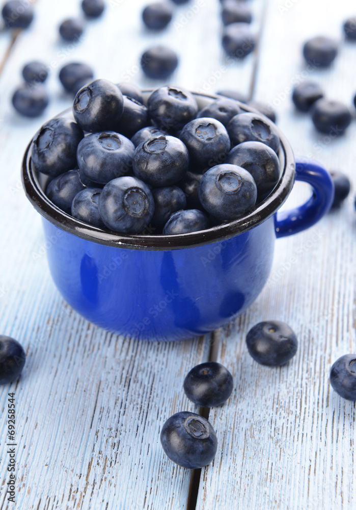 Delicious blueberries in cup on table close-up
