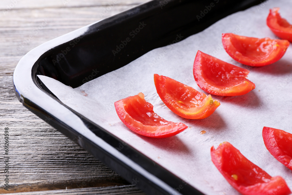 Tomatoes on drying tray, on wooden background