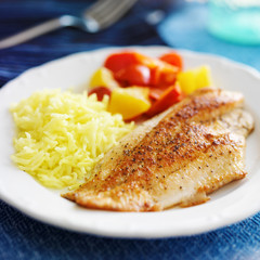 Sticker - fried tilapia filet with yellow rice and colorful bell peppers