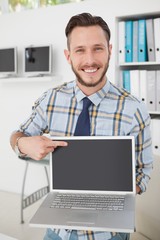 Leinwandbilder - Happy casual businessman pointing to laptop