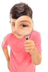 Fototapete - Little boy looking through a magnifying glass