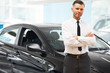 © puhhha - Salesman Stands Near Brand New Car. Car Showroom