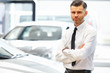© puhhha - Salesman standing in car retail store. Car Showroom.