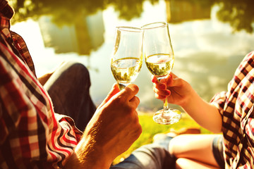 Man and woman clanging wine glasses with champagne