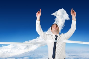 Poster - Composite image of smiling businessman crossing finishing line
