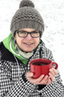 © Edler von Rabenstein - Woman standing in snowy landscape and keeps hot teacup