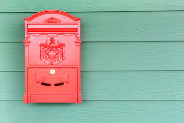 Wall Mural - Red mailbox with green wood background