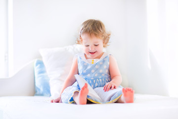 Wall Mural - Little adorable girl reading a book