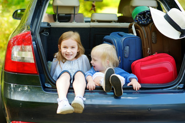 Two little sisters going to a car vacation