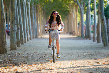 pretty young girl riding bike in a forest.