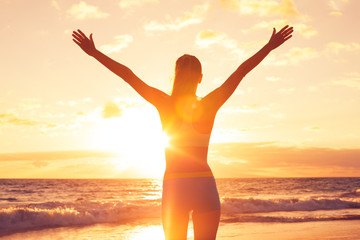 happy free woman at sunset on the beach