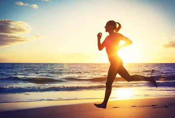 Wall Mural - Woman running at sunset