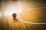 Fototapeta Sport - Basketball ball over floor in the gym