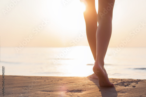 Fotografía Mujer caminando por la playa al atardecer