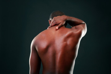 Back view portrait of african man over black background