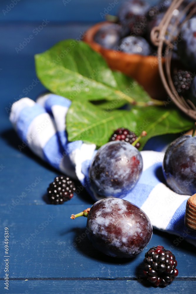 Still life with ripe sweet plums on wooden table