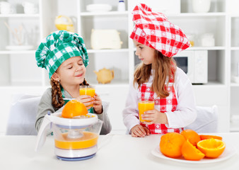 Little chef girls tasting the orange juice they made