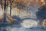 Fototapeta Las - Autumn - Old bridge in autumn misty park