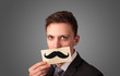 © ra2 studio - Happy businessman holding funny mustache card on his mouth