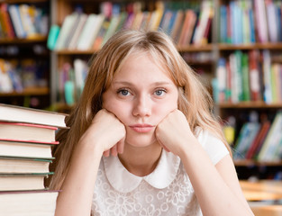 Sad female student in library looking at camera