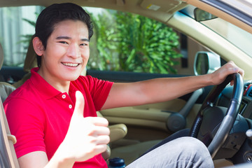 Asian man driving new car