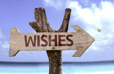 Wishes wooden sign with a beach on background