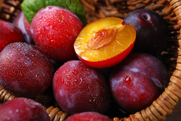 fresh plums falling out of a basket