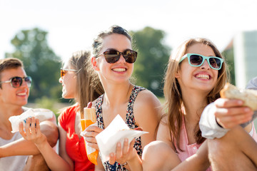 Wall Mural - group of smiling friends sitting on city square