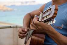 Guy Playing Guitar On A Balcony On The Sea