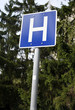 © acceptfoto - Hospital this way traffic sign above green background