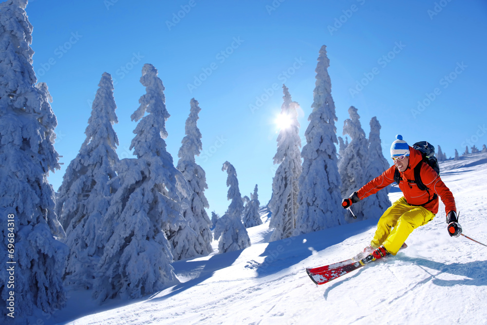 Skier skiing downhill in high mountains against sunset - obrazy, fototapety, plakaty 