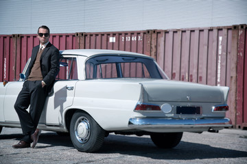 Retro 60s fashion business man wearing grey suit and black sungl