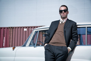 Retro 60s fashion business man wearing grey suit and black sungl